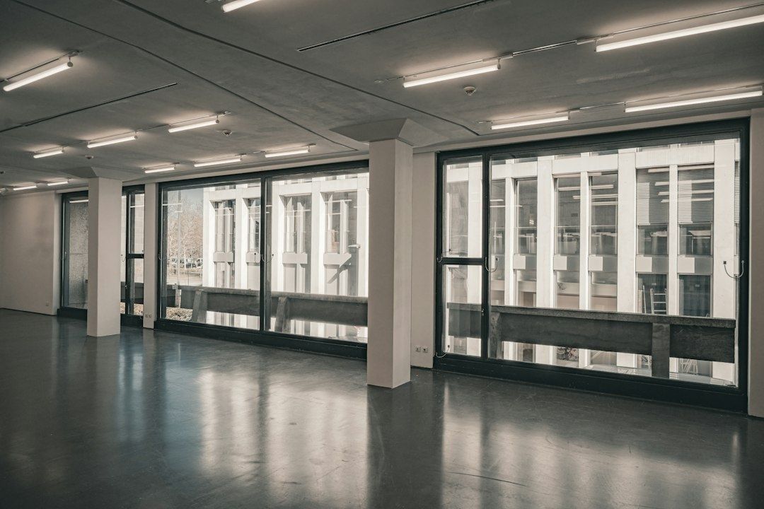 Leerer, industriell wirkender Ausstellungsraum mit großen Fenstern